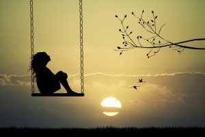 Girl on swing at sunset